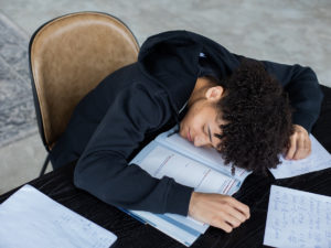 Student taking a power nap after studying. Find out about the pros of taking breaks while studying right here.