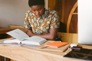 Student studying from her textbook for her final matric exam. Learn how to prepare for your final matric exam right here.