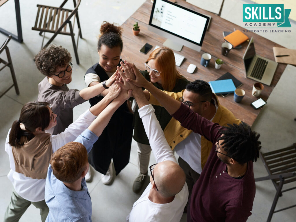 Team giving each other a high five. Teamwork is one of the 11 soft skills every professional needs.
