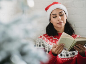 Woman studying while wearing a Christmas hat. Find out how to stay productive this festive season right here.