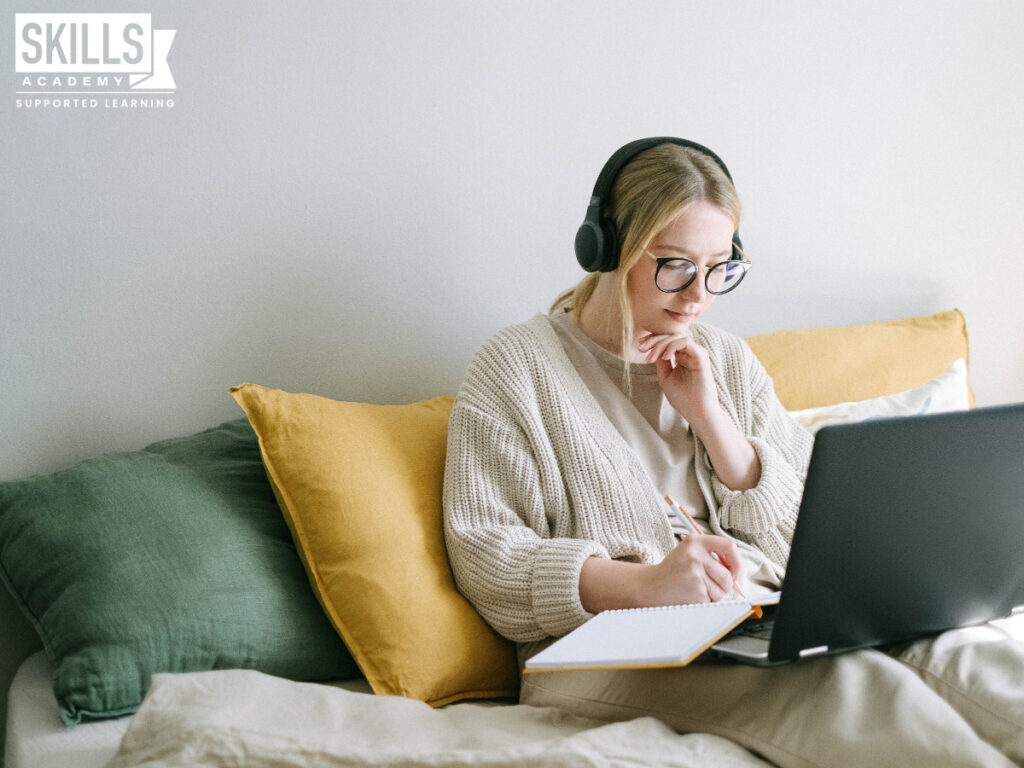 Woman sitting on a couch working from home. Learn How to work from home successfully with us.