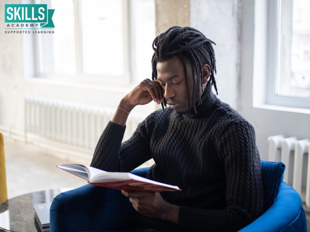 Student sitting on a chair reading a book. With us, you can study further with your Amended Senior Certificate.