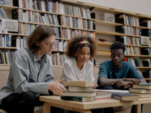 Three students sitting in a library studying together. Learn how you can study further with your Amended Senior Certificate.