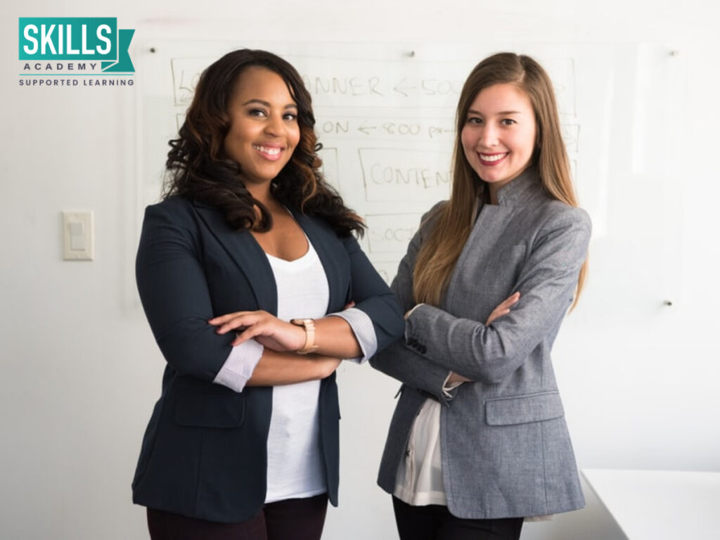 Two ladies standing next to each other crossed arms. Top Courses for Business Professionals.