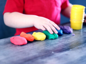 Child playing with coloured dough. What Qualifications Do I Need to Become a Childcare Worker