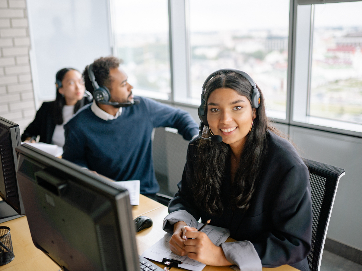 Three people with headsets sitting behind their monitors. 10 Ways to Improve Your Customer Service Skills