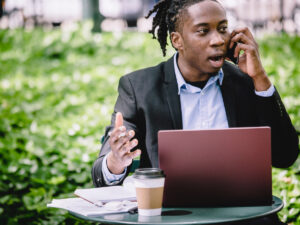 Guy talking on the cellphone in front of laptop. 9 Benefits of Work Experience
