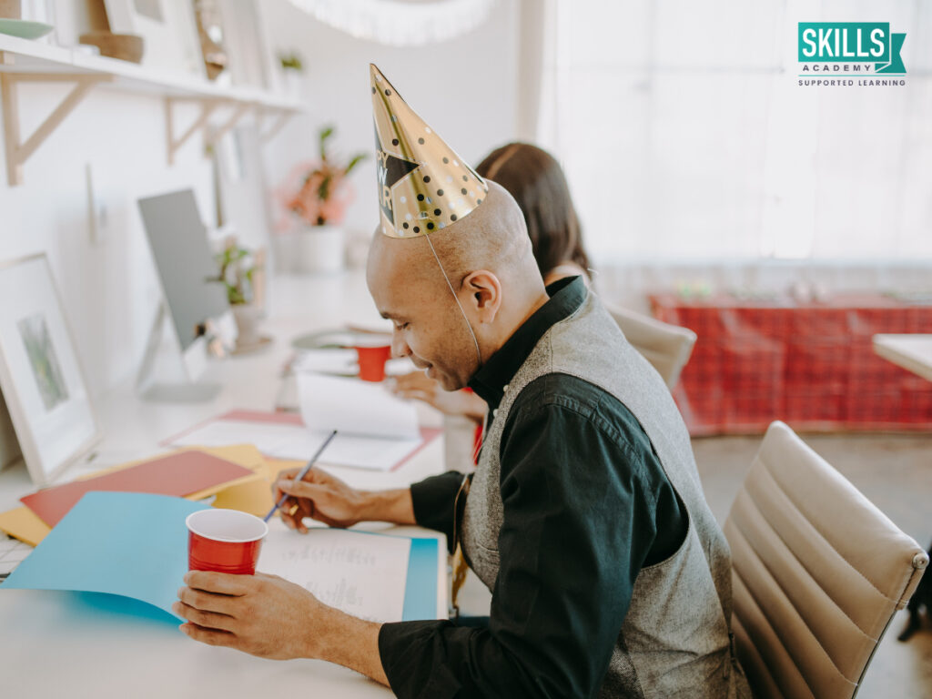 Guy with party hat on, writing notes. How to Start a Career in Events Management