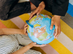 Two people holding an earth globe. Where Can I Study With my Matric Certificate