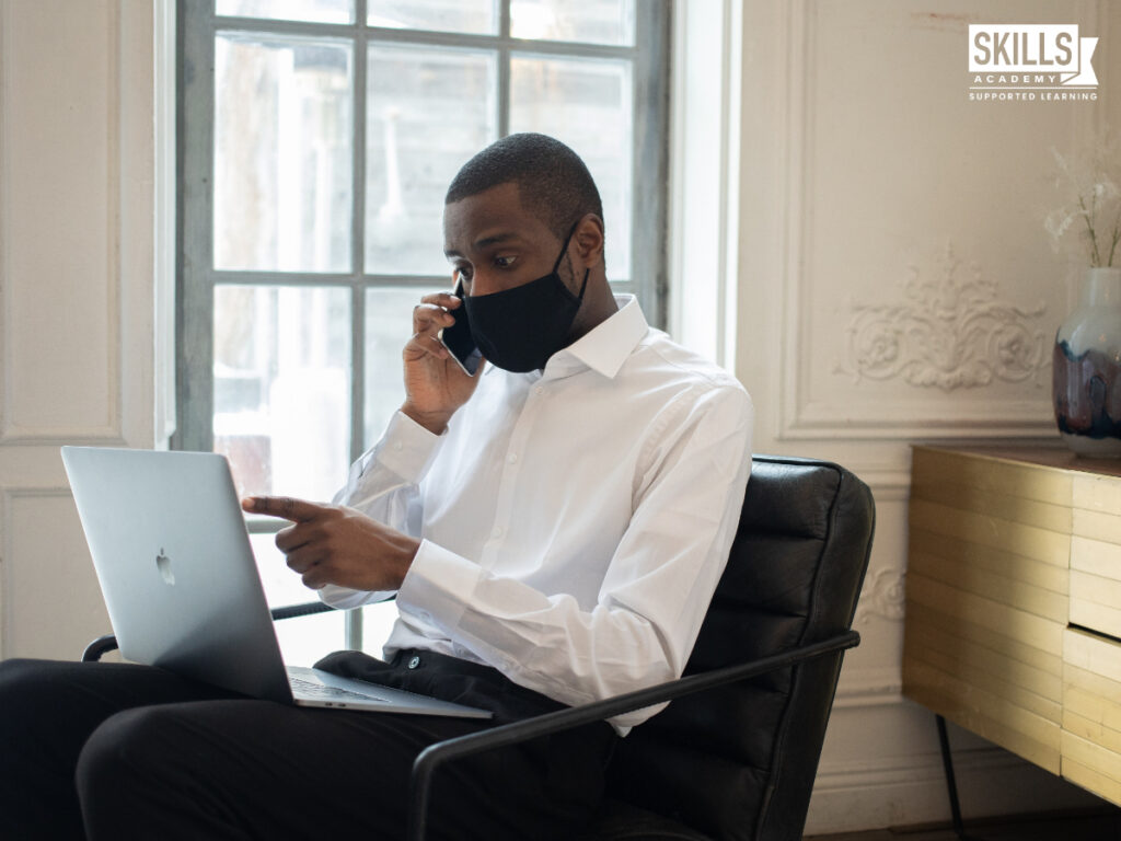 Guy working on laptop with his mask on. 10 Tips to Help you Succeed in Your new job