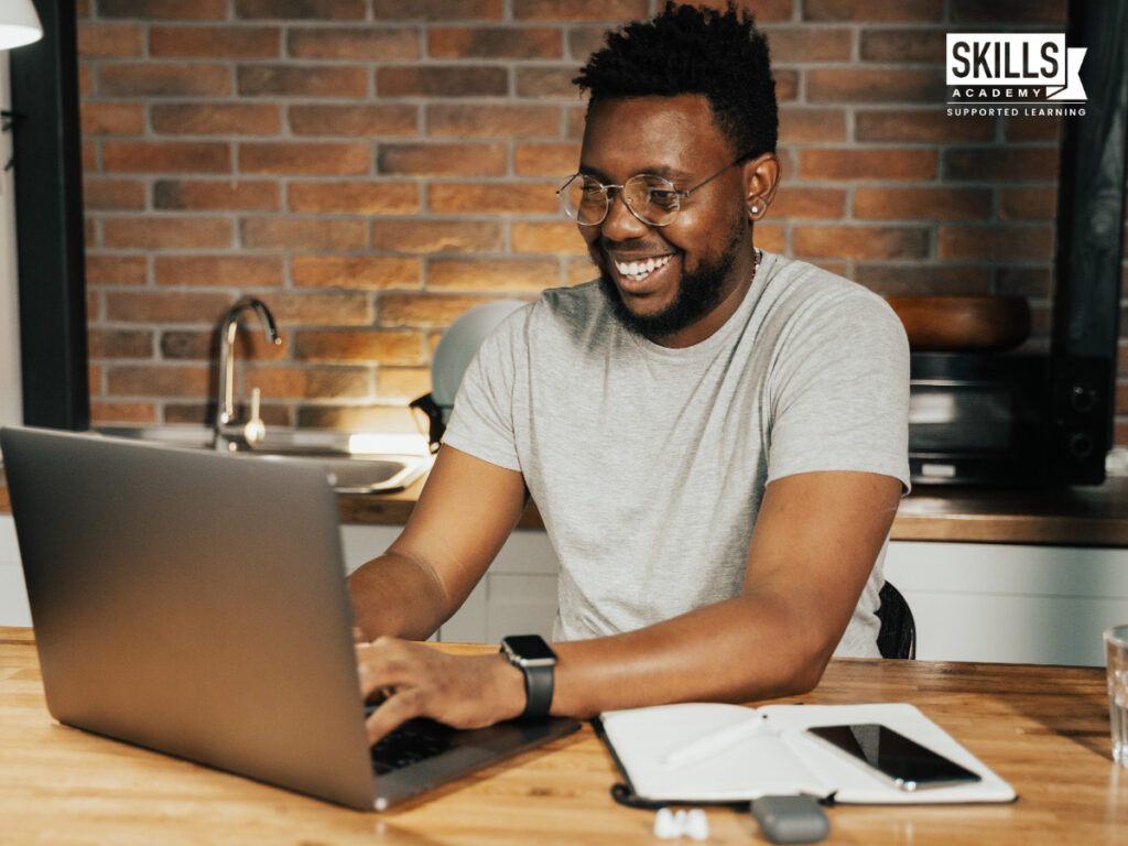 Guy smiling while reading his laptop. A Step-By-Step Guide to Skim Reading