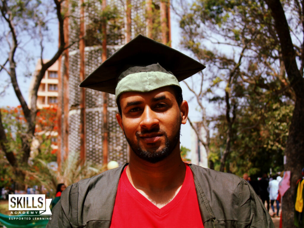 Guy with graduation hat on looking at the camera. Benefits of Studying an Accredited Course