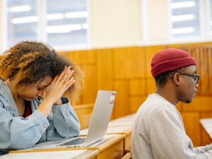 Girl and guy sitting in class looking stressed. How to Study if you Have to Cram
