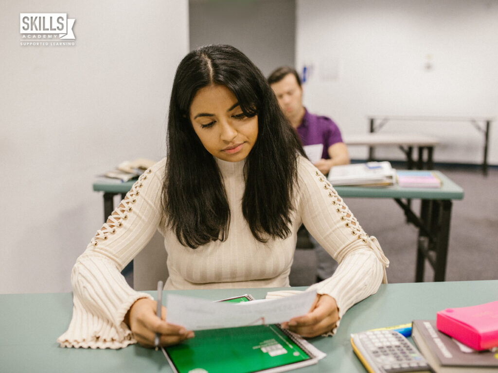 Girl sitting in class with notes infront of her. Matric Equivalent Courses