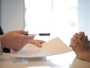 Guy handing someone a contract. Reasons why you Should Choose a Career in Insurance