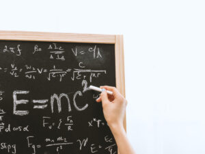 Person doing math on a black board. Choosing Between Maths and Maths Literacy.