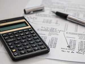 Calculator and a pen on paper. Accounting Diploma Courses
