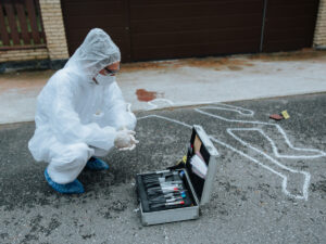 Forensic in body suit kneeling. Forensic Science Courses you can Study Online