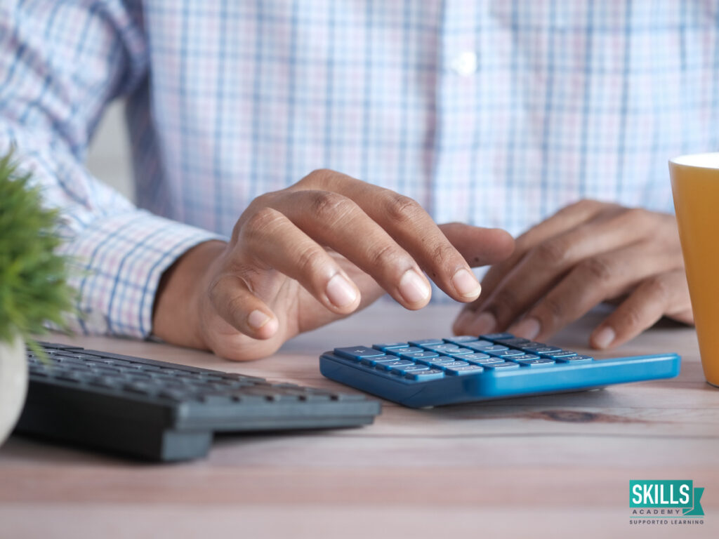 A person using a calculator to help them study bookkeeping courses online. Study our courses today!