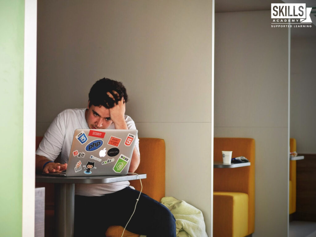 Student sitting at a table looking at a laptop with his hand in his hair. What are your options if you failed the ICB exam? Find out right here.