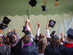 Group of people throwing their graduation hats in the air. ICB Qualifications.