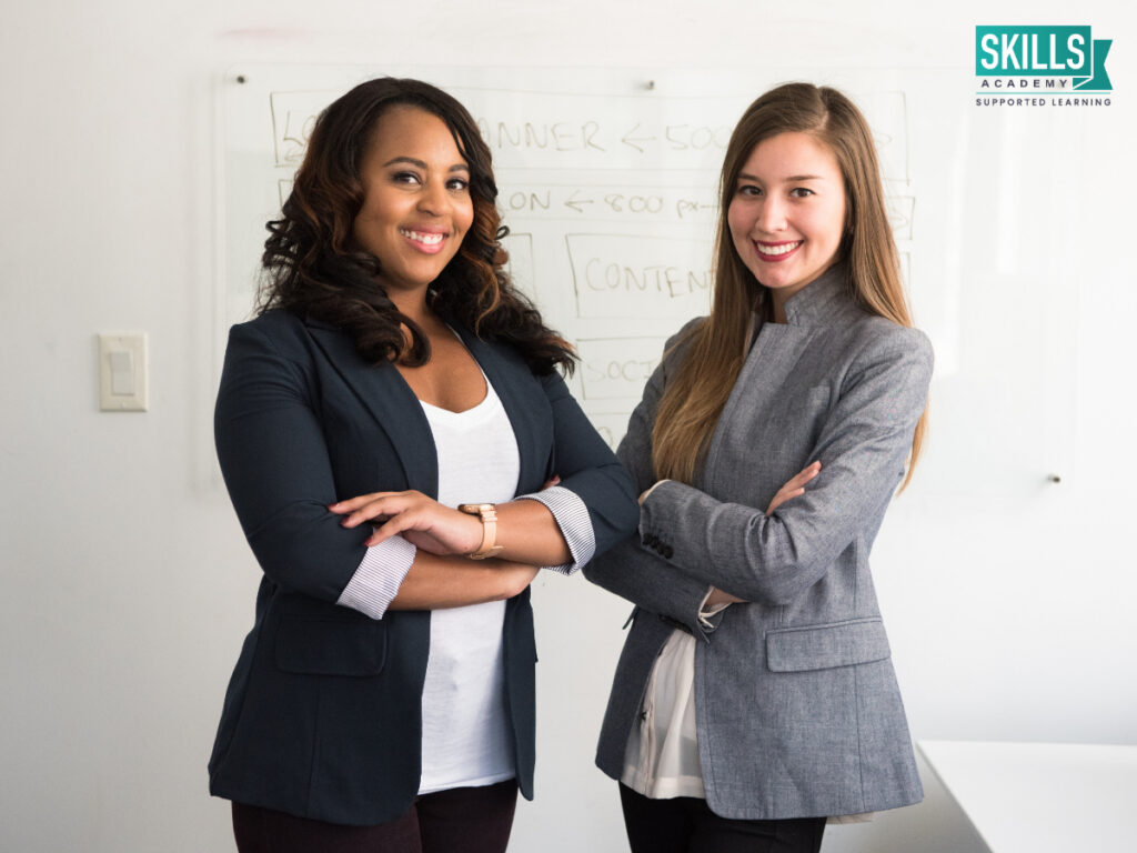 Two professionals crossing their arms and looking at the camera. Study Business Management Online with us today!