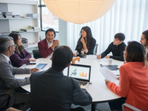 Group of people having a meeting around a table. Where to Study Business Management Online in South Africa.