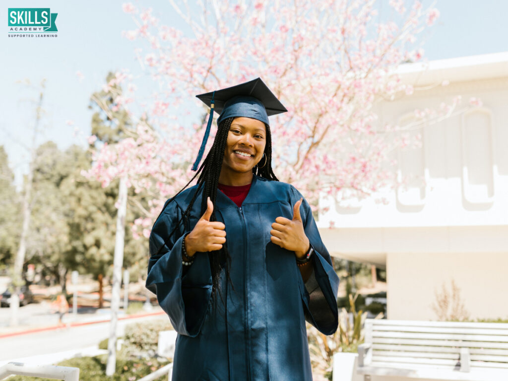 Girl in graduation clothes with her thumbs up. Qualifications you Need to Become a Bookkeeper.