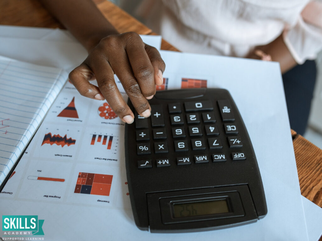 An accounting student using a calculator. Check out the ICB Courses in Limpopo right here.