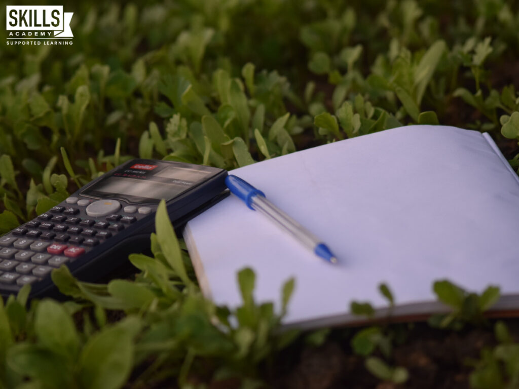 Calculator and notebook in grass. Study finance from anywhere in South Africa. Learn quality skills when you study ICB courses in Mpumalanga.