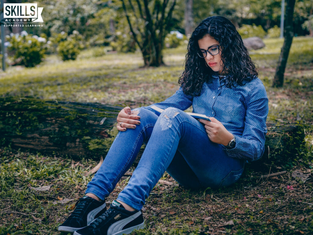 Student reading in a forest. Take your skills to the next level when you study ICB courses in the Western Cape.