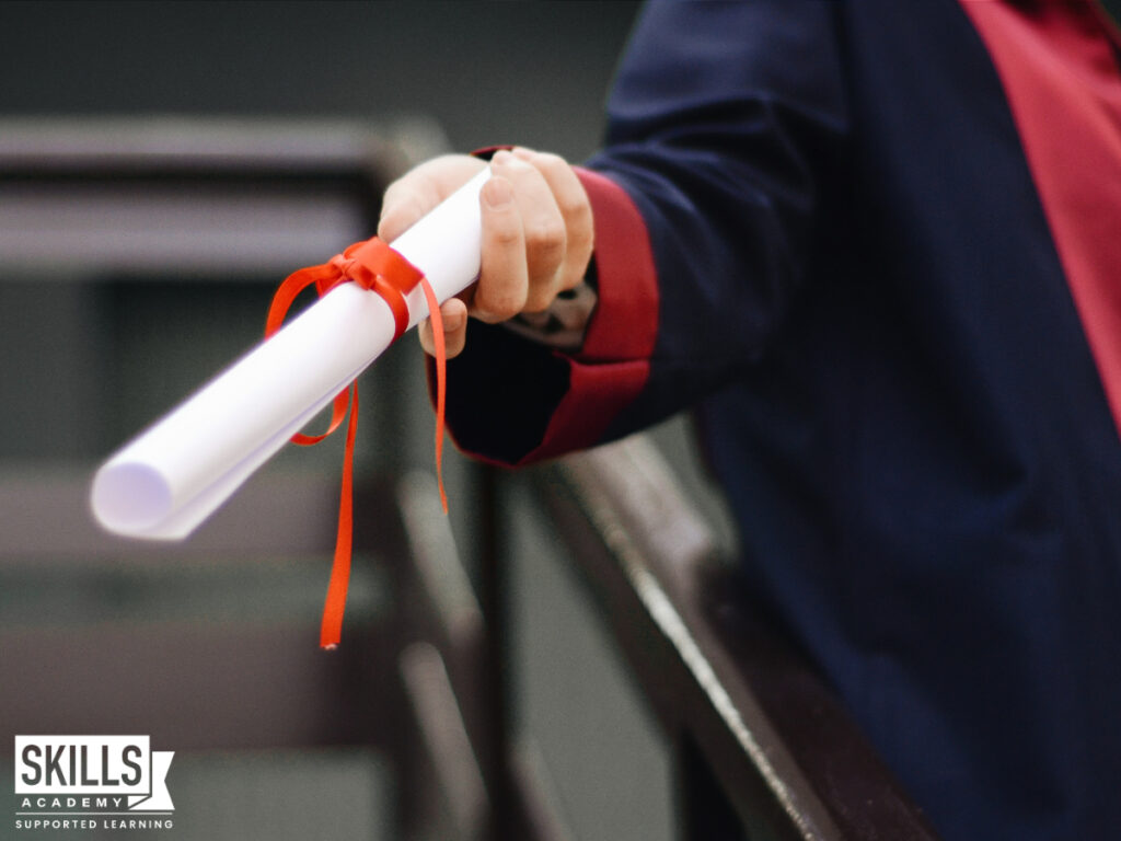 A graduate holding a diploma. Find out more about the qualifications needed to work in office administration right here.